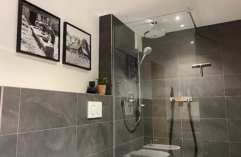 Modernes Bad mit dunklen Fliesen