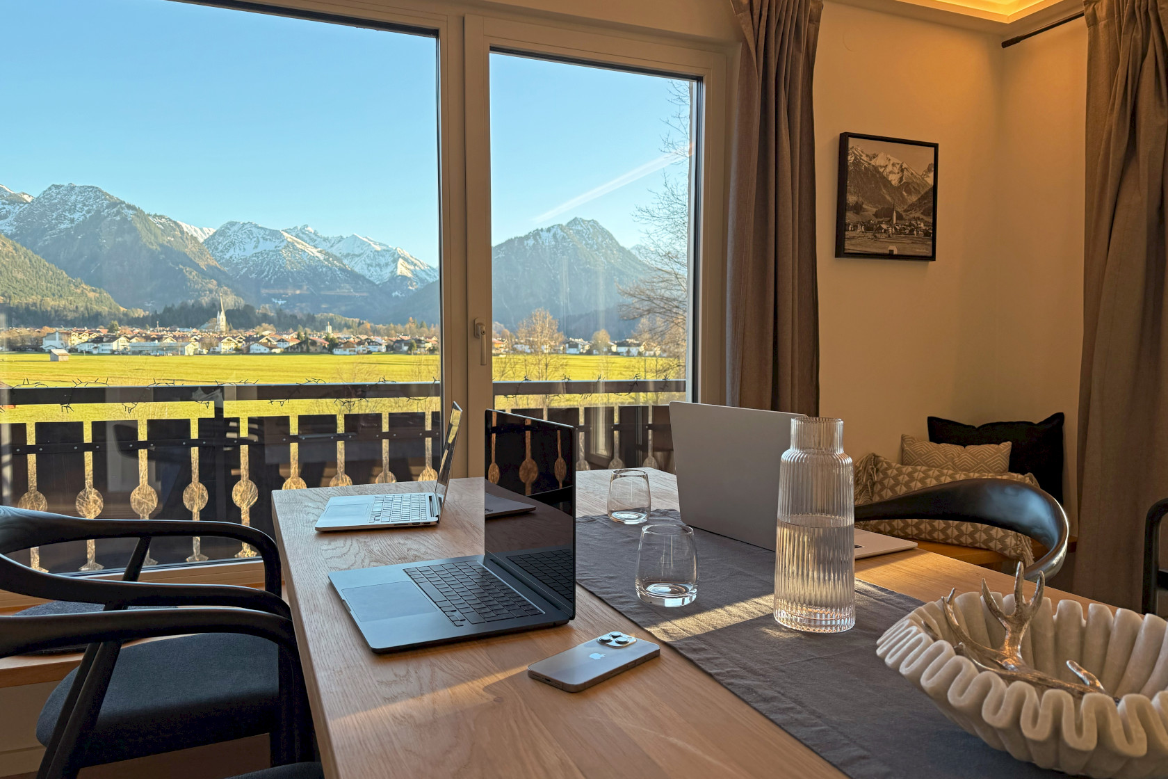 Drei Laptops auf dem Esstisch im Klopfer Haus mit Ausblick auf Oberstdorf und die Berge